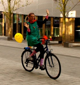 Clownin LOTTE fährt freihändig Fahrrad